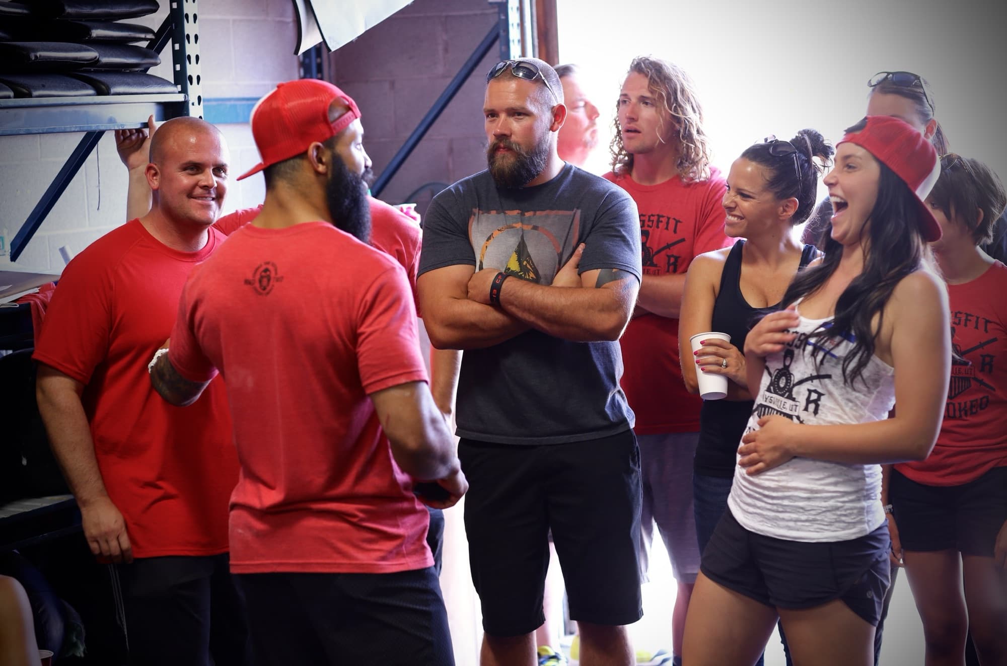 Gym members in red shirts laughing together after a workout