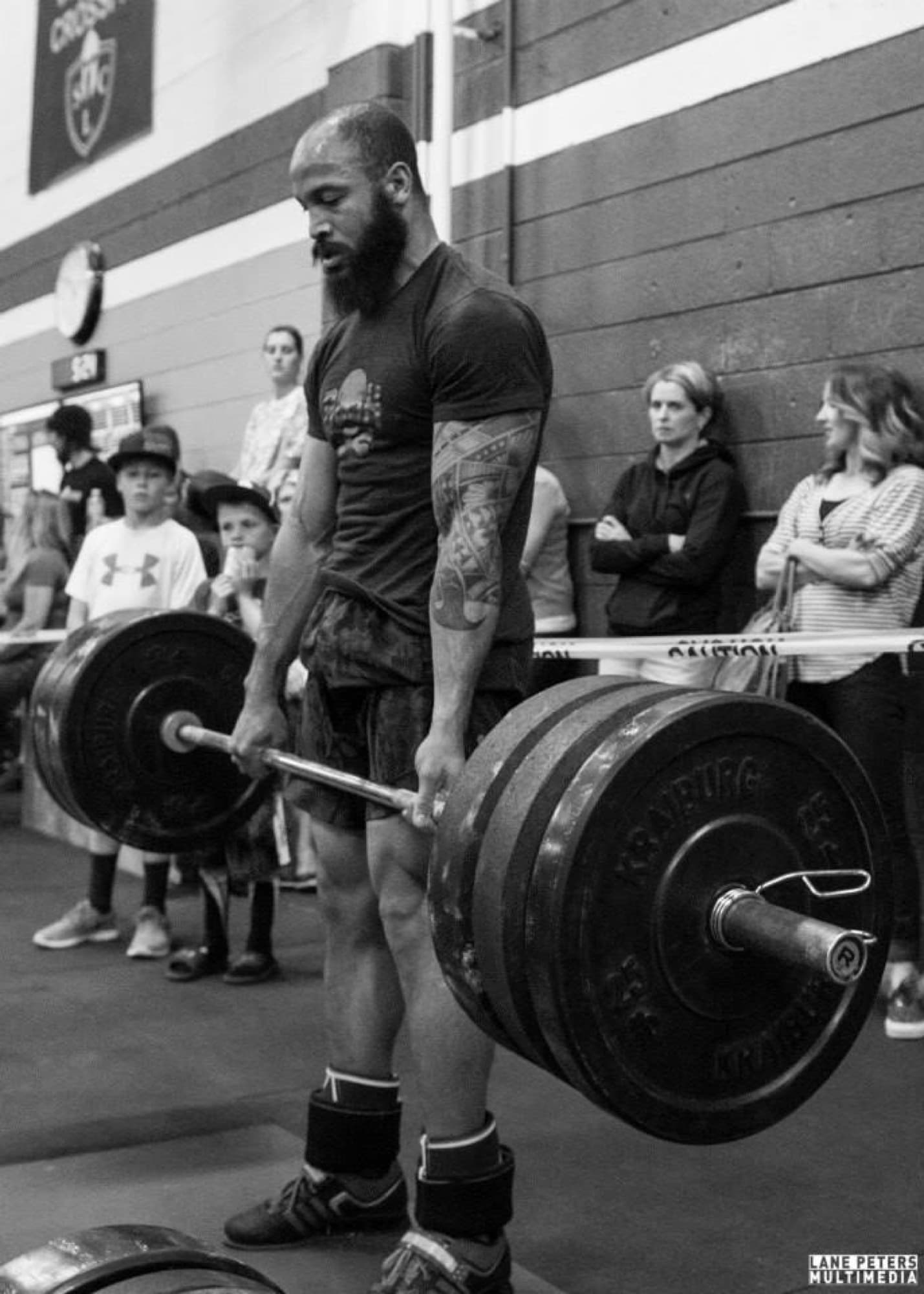 Black-and-white photo of Matt Byrd locking out a heavy deadlift in competition
