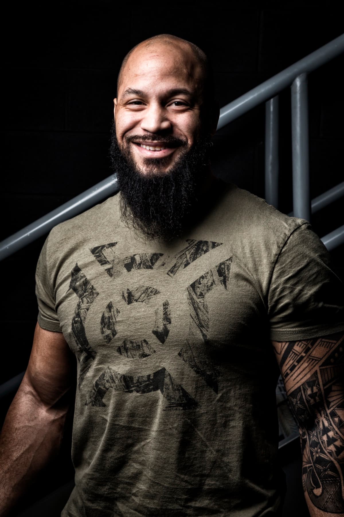 Coach Matt Byrd smiling in a studio portrait on a stairway